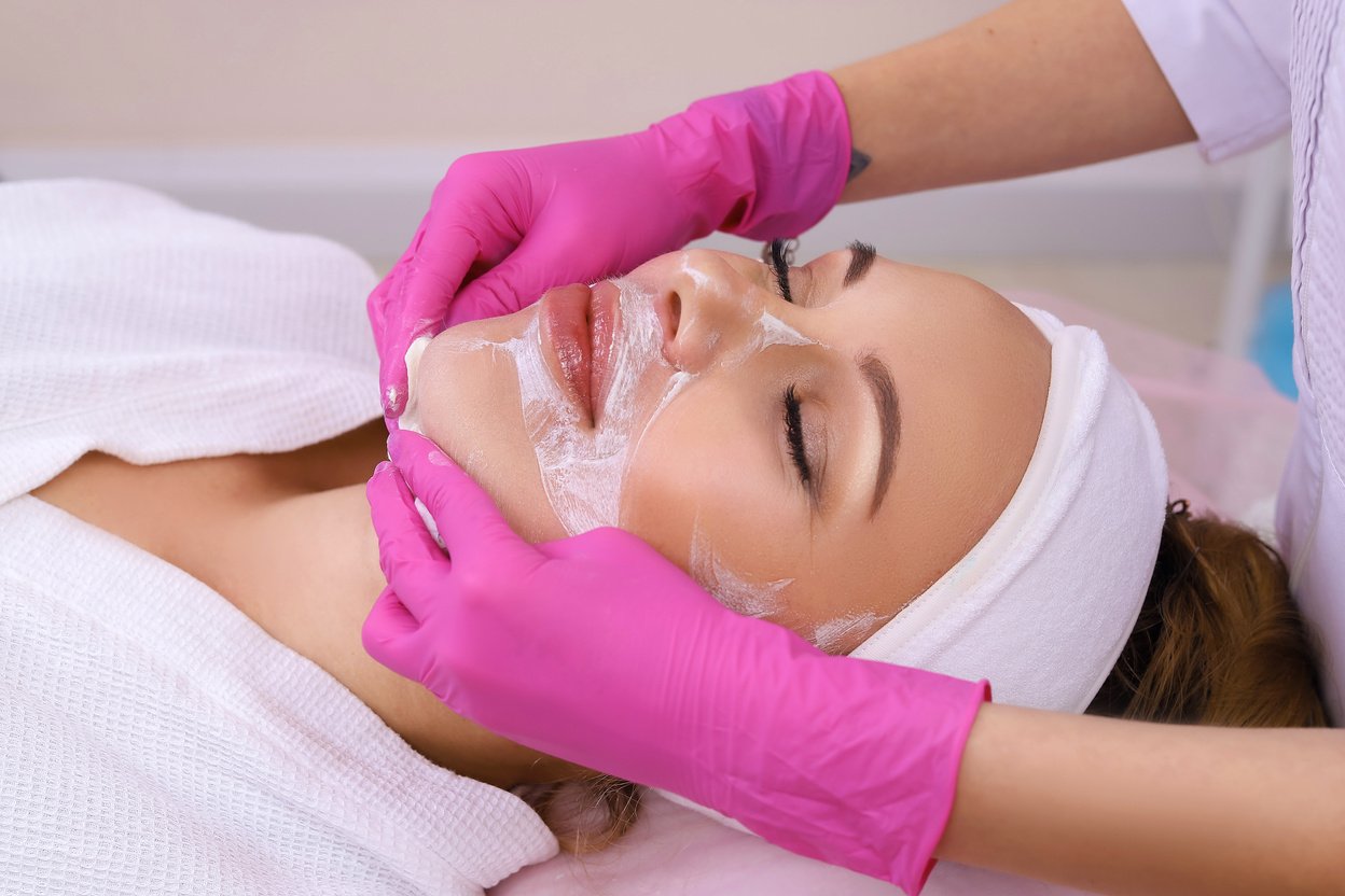 Spa Woman applying Facial cleansing Mask.