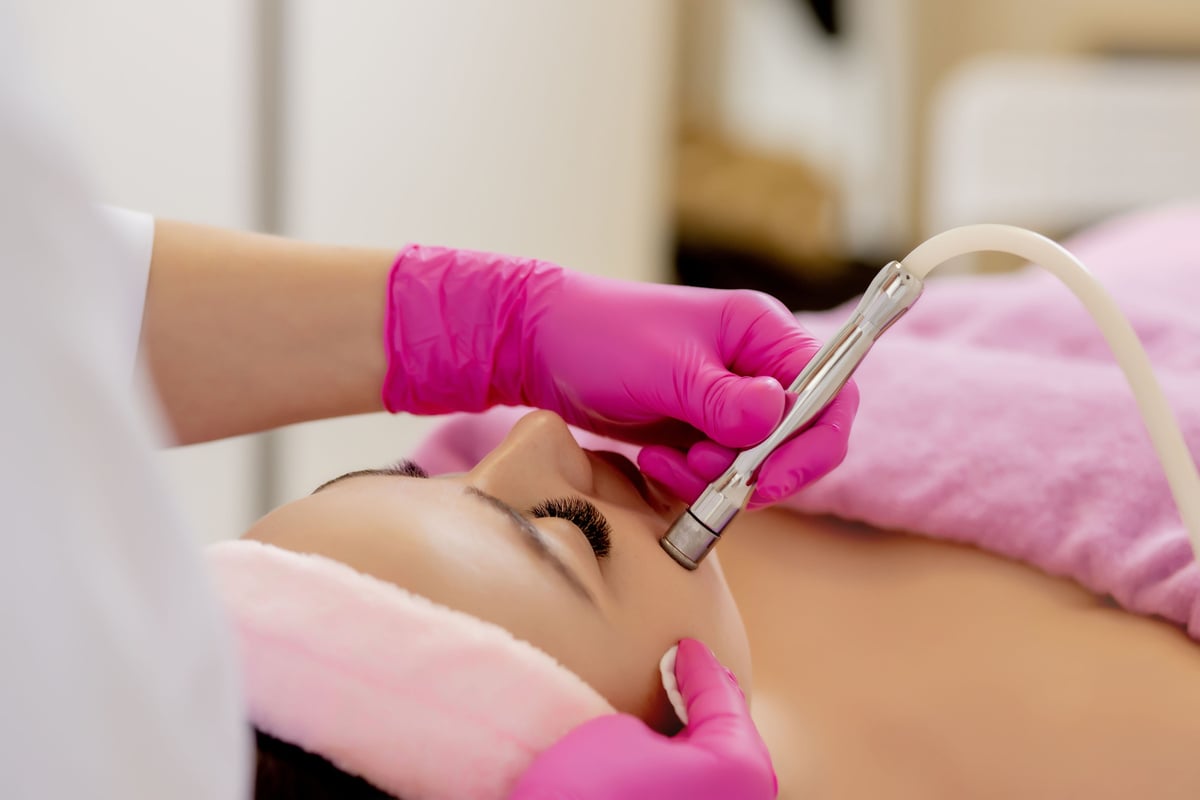 The cosmetologist makes the procedure Microdermabrasion of t